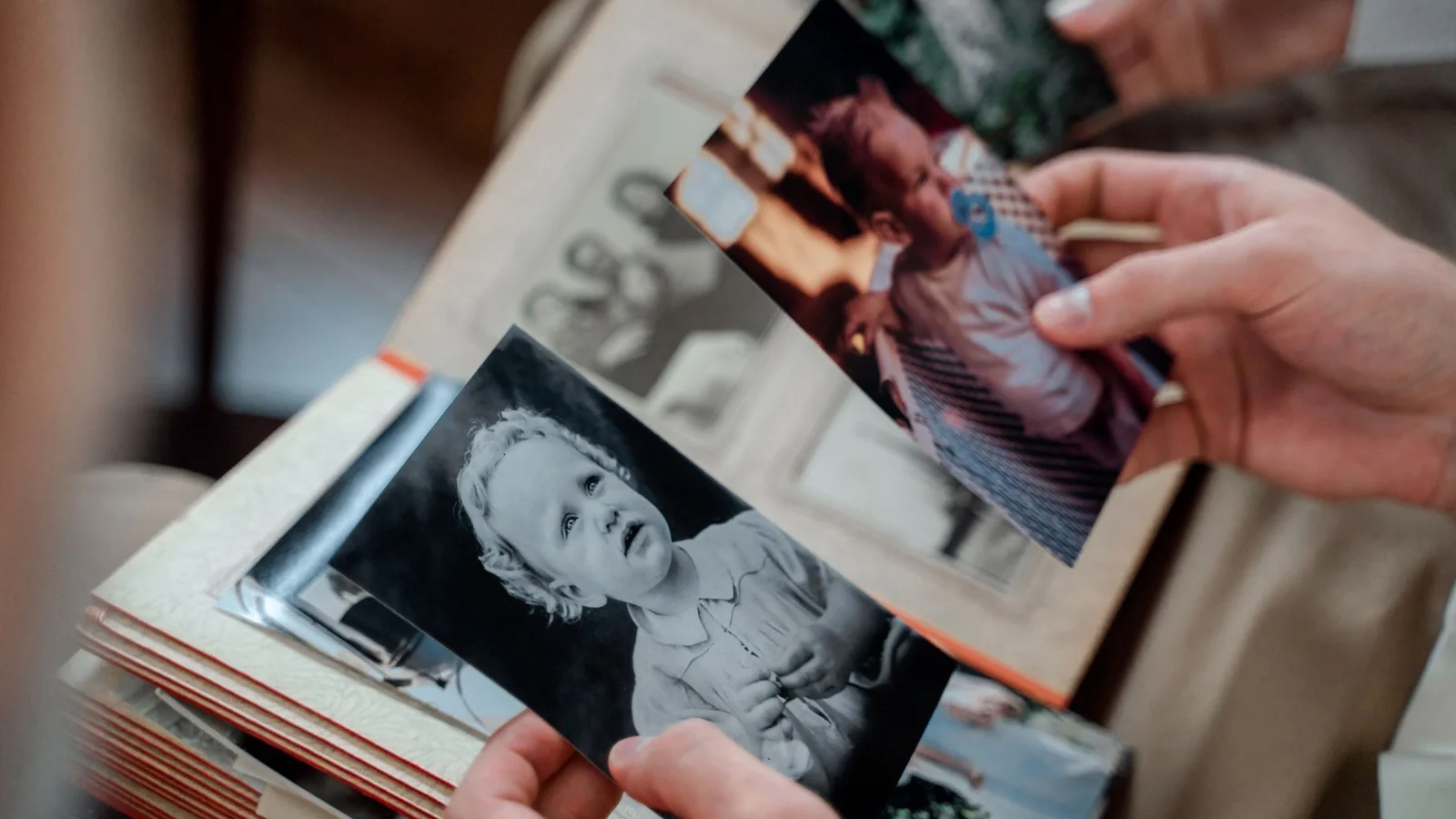 Hands holding old black and white family photos to animate with a AI